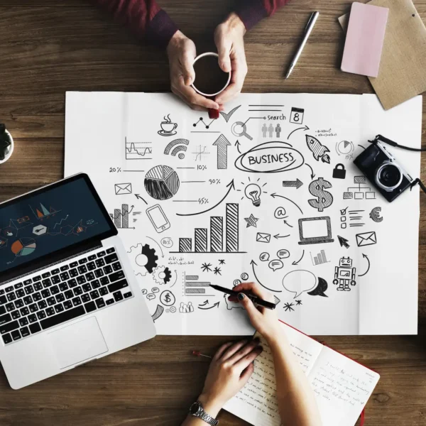 Laptop und Plakat mit Marketing Mix auf einem Schreibtisch.